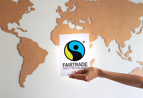 Fairtrade Deutschland Logo vor einer Weltkarte