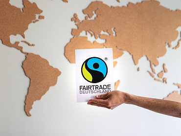 Fairtrade Deutschland Logo vor einer Weltkarte