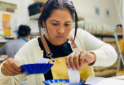 Frau präpariert Kaffeebohnen für Verköstigung im Rahmen des Wettbewerbs Taza Dorada in Guatemala