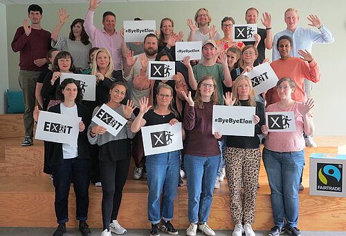 Das Team von Fairtrade Deutschland mit Schildern mit dem eXit-Logo